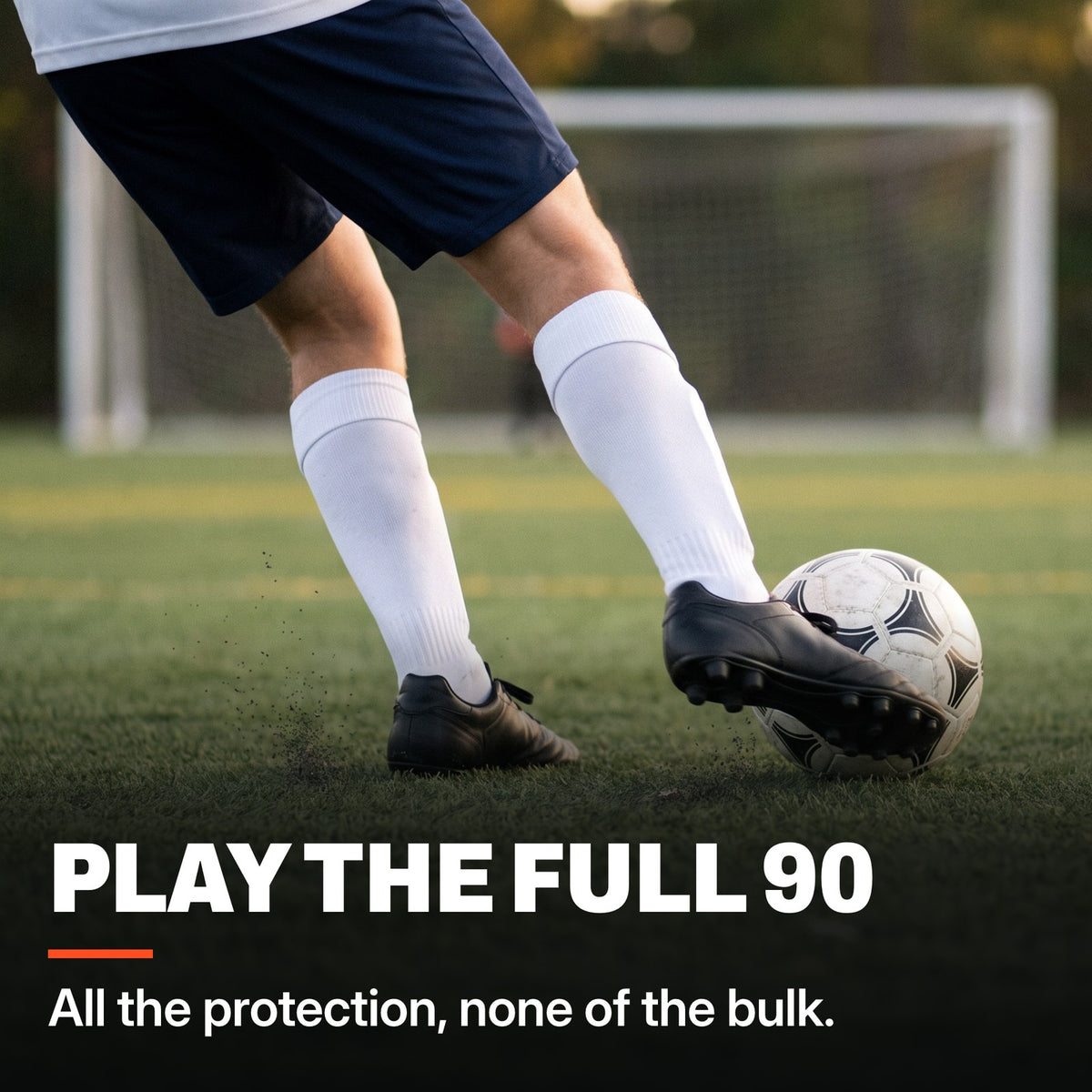 Teenage soccer player striking a ball on a turf field